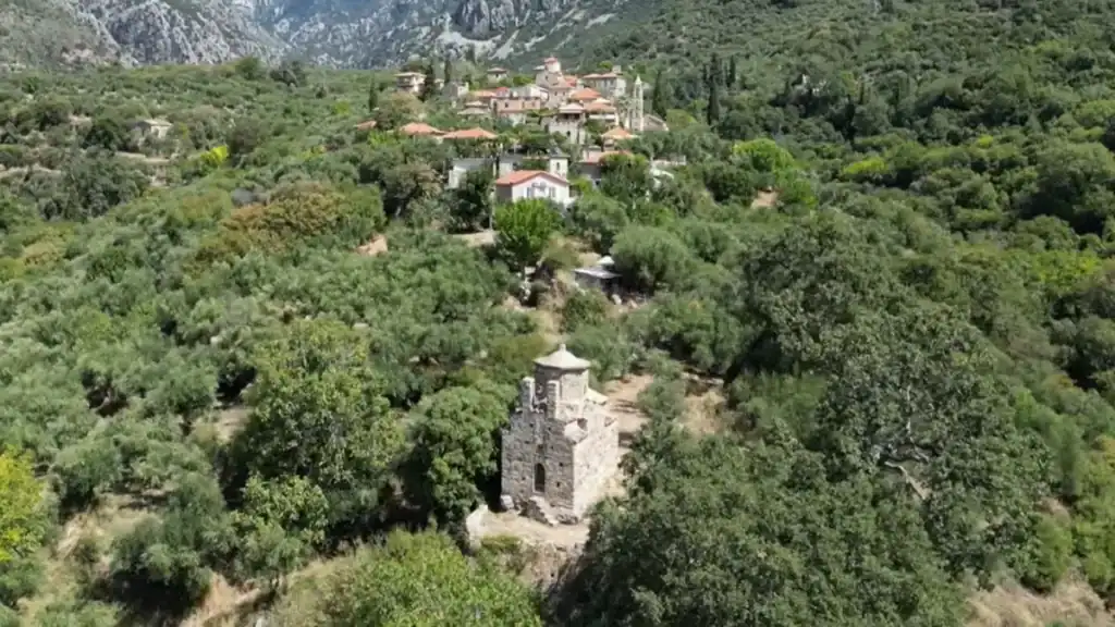 Where to Stay in Mani village nestled in greenery near mountains.