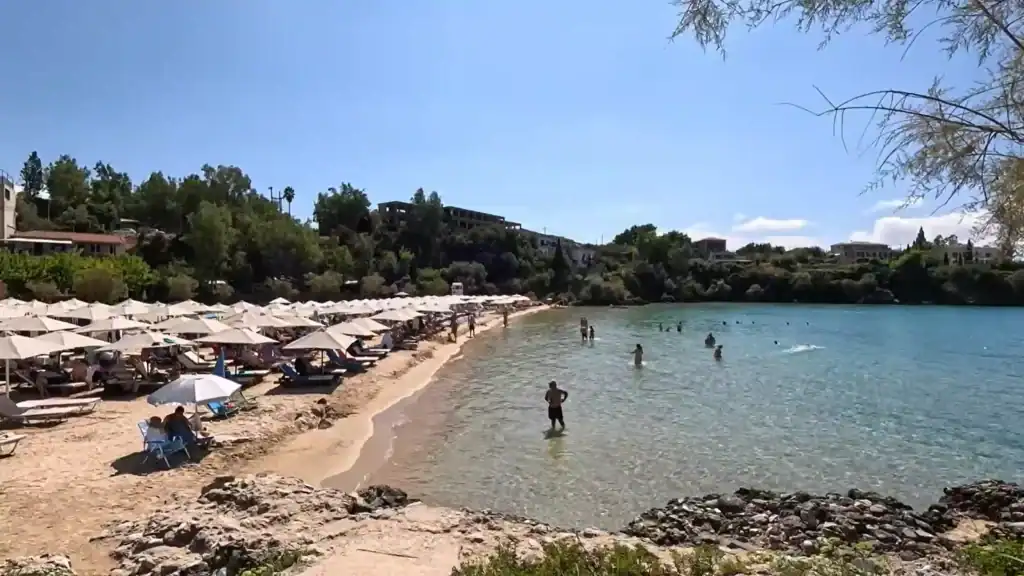 Kalogria Beach in Stoupa, one of the sheltered Mani Peninsula beaches, with sunbeds and clear turquoise water