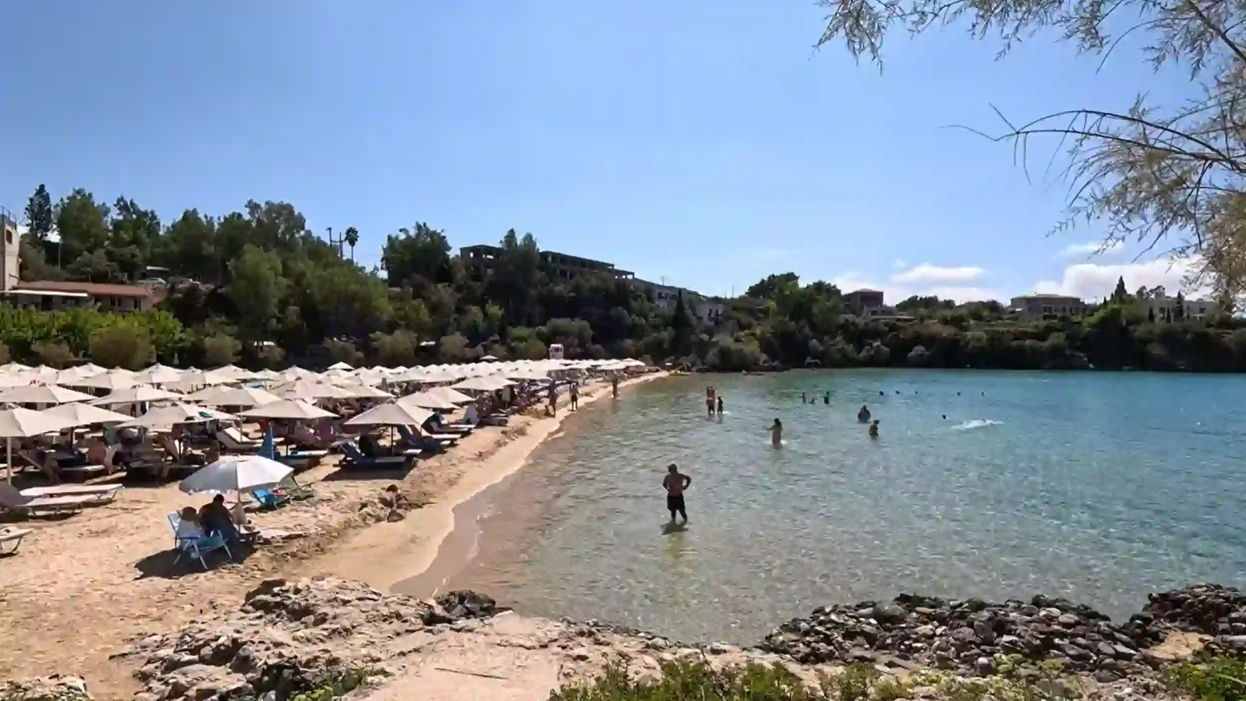 Kalogria Beach in Stoupa, one of the sheltered Mani Peninsula beaches, with sunbeds and clear turquoise water