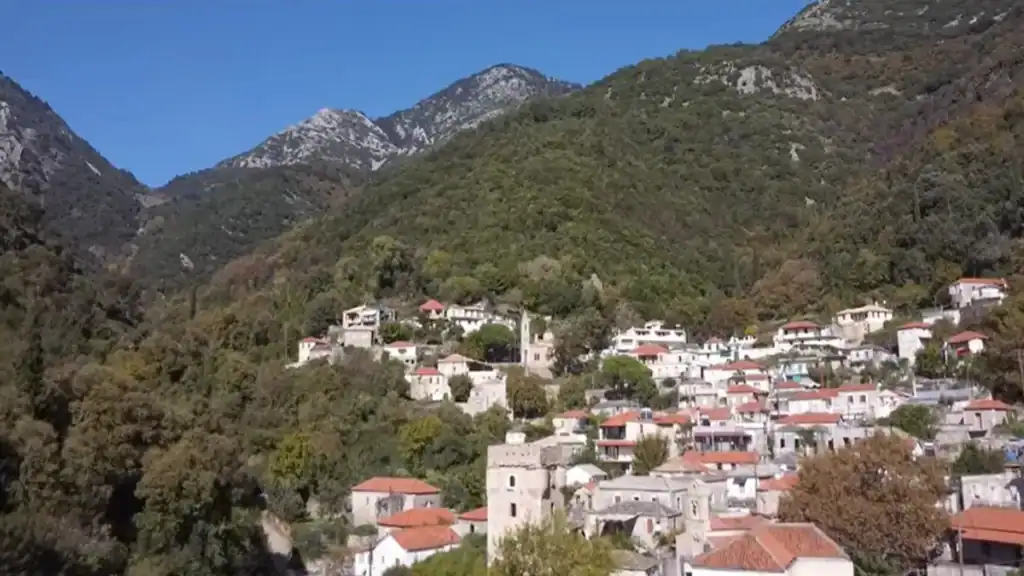 Kastania village nestled among forested Taygetos mountain slopes under a clear blue sky