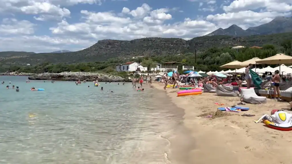 Kalogria Beach showing sandy shoreline with mountain backdrop.