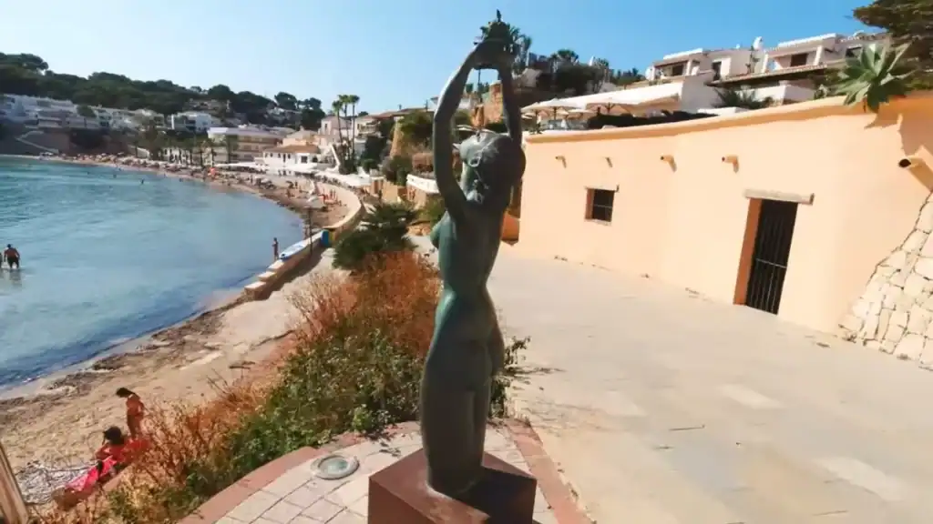 Moraira vs Calpe village charm with beachside statue and whitewashed buildings.