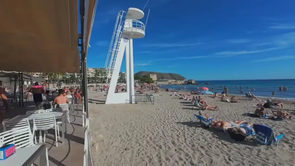Moraira beaches feature golden sand and lifeguard tower at Playa Ampolla.