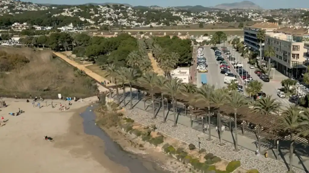 Playa de la Ampolla with promenade and parking facilities.
