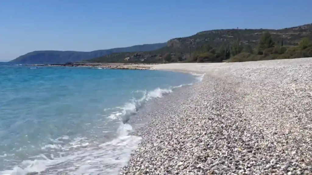 Kardamyli Beach with crystal clear turquoise waters and pebble shoreline.
