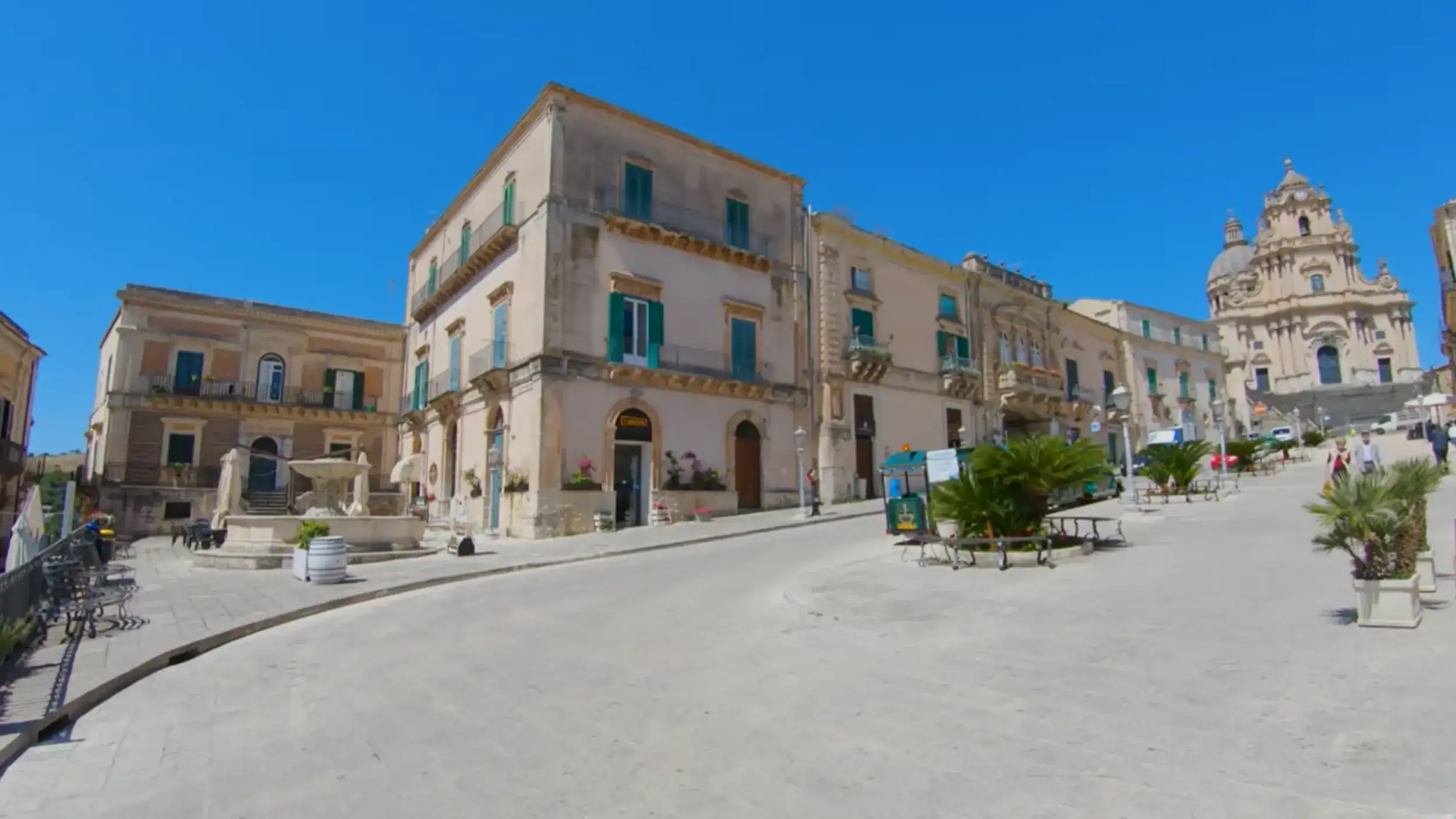 Ragusa Ibla travel starts here for many visitors - Piazza del Duomo opens across pale stone paving with the Cathedral of San Giorgio's ornate facade rising to the right