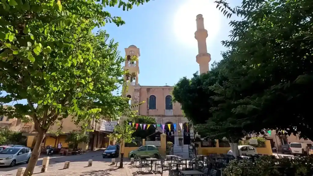 Church of St Nicholas in Chania's Splantzia square, bell tower and minaret rising side by side above the tree-lined plaza