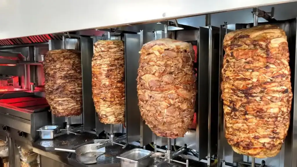 Four large gyros spits loaded with layered meat rotating on vertical rotisseries, a reliable lunch stop for eating well during Chania in November