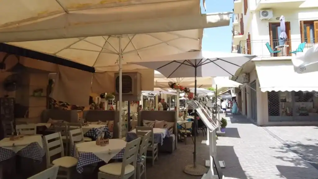 Shaded outdoor taverna tables with blue checked cloths in a Chania side street, the kind of lunch stop that fits naturally into one day in Chania
