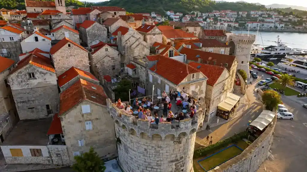 Aerial view of crowds gathered on Massimo Cocktail Bar tower at sunset in Korčula Town