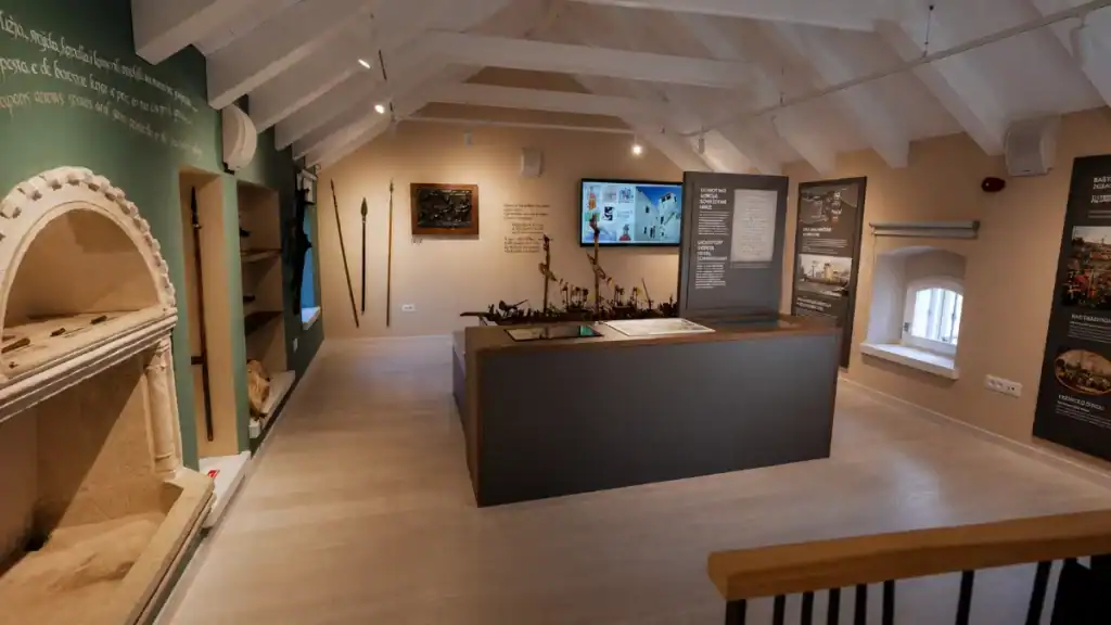 Interior exhibition room of the Marco Polo Museum with weapons and display panels, Korčula
