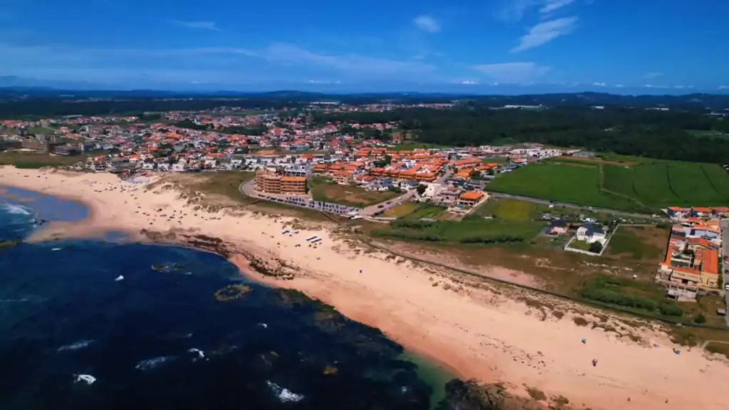 Aerial view of Vila do Conde coastline with sandy beach and terracotta-roofed town
