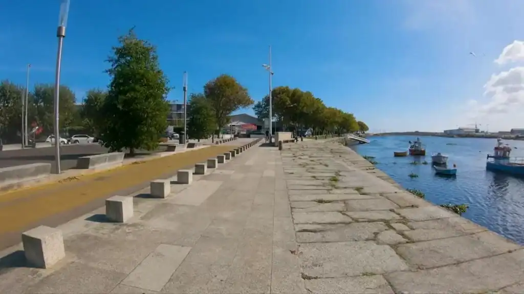 Riverside cycle path beside moored fishing boats on the Vila do Conde cycling route along the Ave