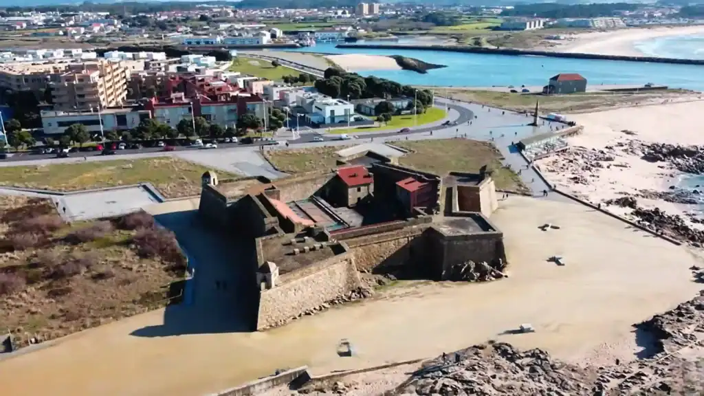Aerial view of Vila do Conde fort on a sandy coastline with the town behind