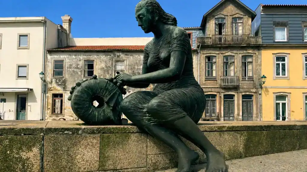 Bronze lacemaker statue working a bobbin pillow in Vila do Conde historic centre