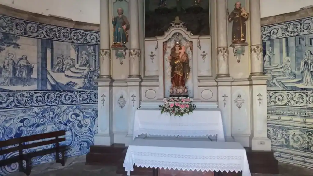 Blue and white azulejo panels flanking a gilded altar with a Madonna statue