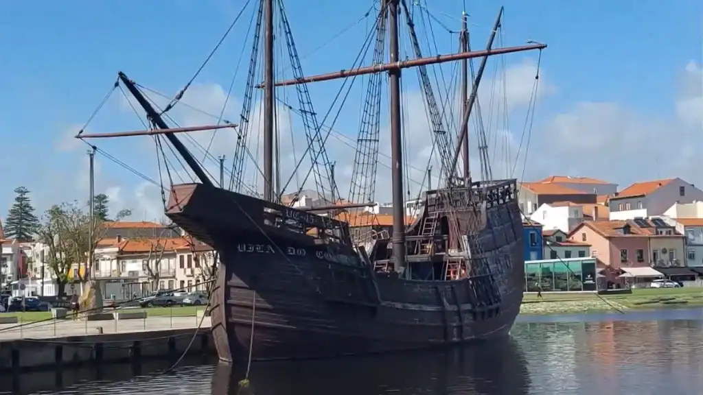 Full-scale replica of a Portuguese caravel moored on the River Ave with the town behind
