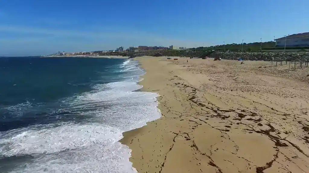 Wide Atlantic beach stretching north with breaking waves, one reason Vila do Conde worth visiting for the coast