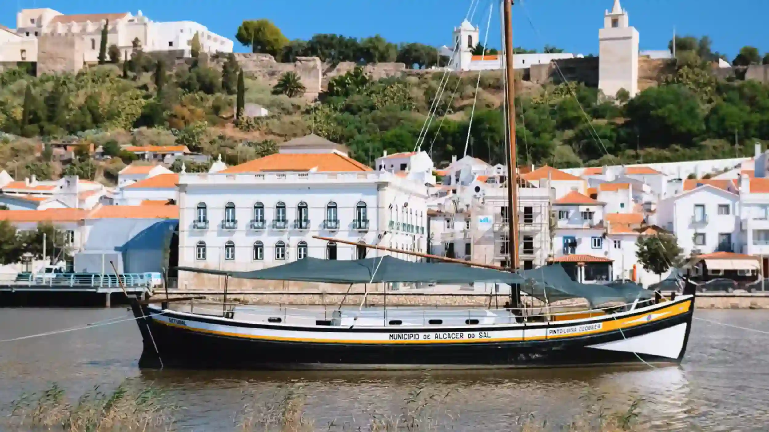 Traditional wooden sailing boat marked MunicÃpio de Alcácer do Sal moored on the River Sado