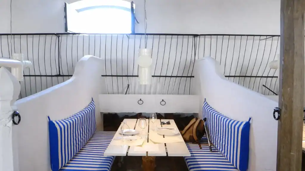 Blue and white striped booth seating inside a coastal restaurant in Comporta village