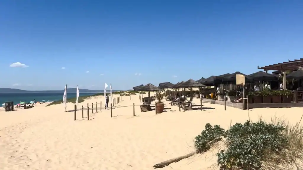 Beach restaurant with thatched parasols on wide dunes proves Comporta worth visiting for its coastline