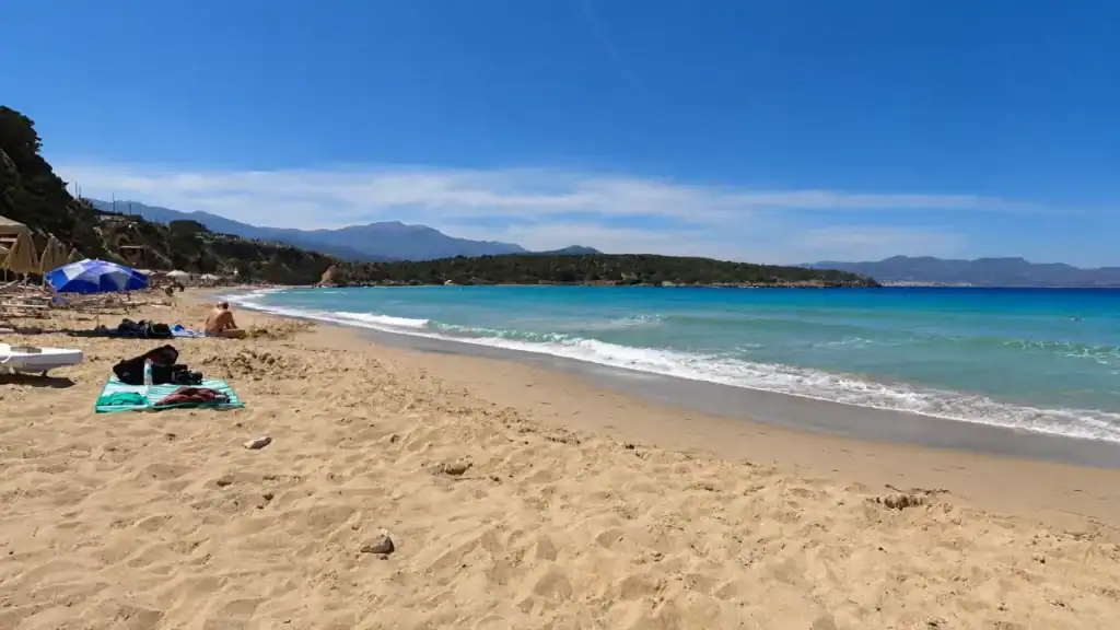 Golden sand and turquoise shallows stretching across Voulisma Beach near Istron village