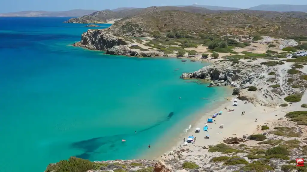 Twin sandy coves separated by a rocky headland along the Itanos coastline