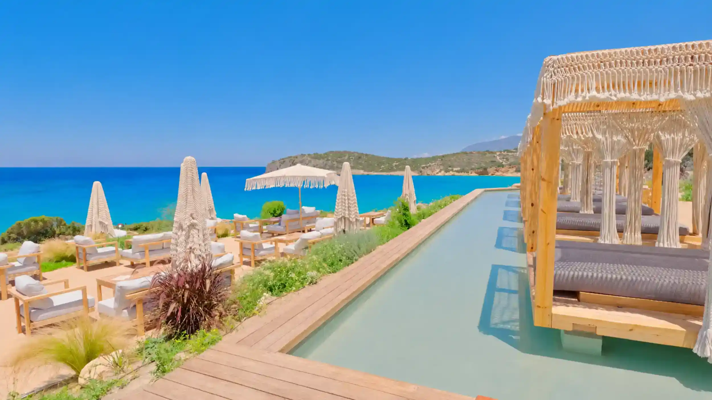 Macramé cabanas and infinity pool overlooking Voulisma Beach, East Crete travel guide essential.