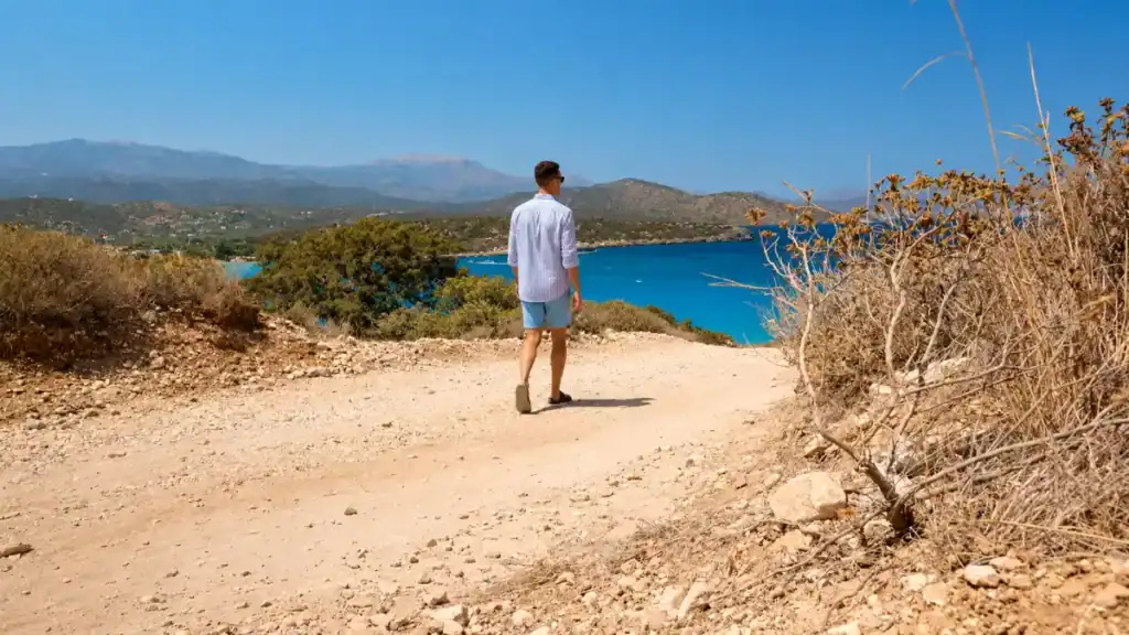 Man walking coastal track above Mirabello Bay near Agios Nikolaos