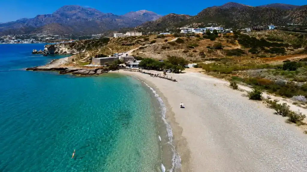 Curved white pebble beach and turquoise shallows at Diaskari near Makry Gialos.