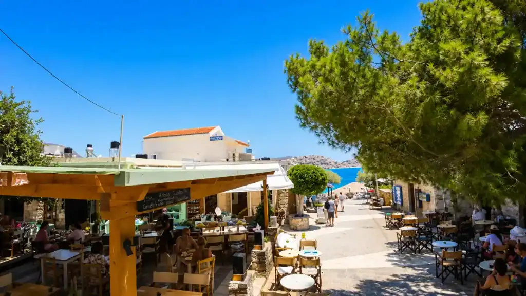 Diners seated at seafront tavernas along the main street in Plaka village