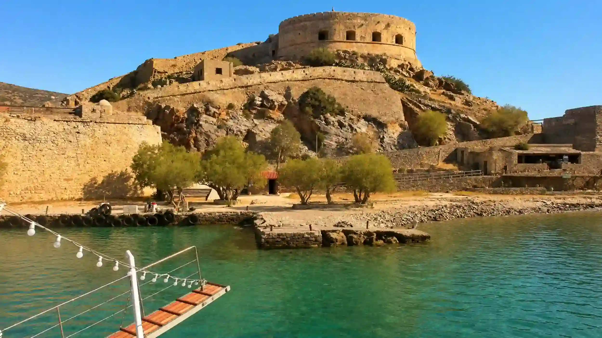 Boat gangway approaching Spinalonga fortress walls when visiting Spinalonga from Elounda