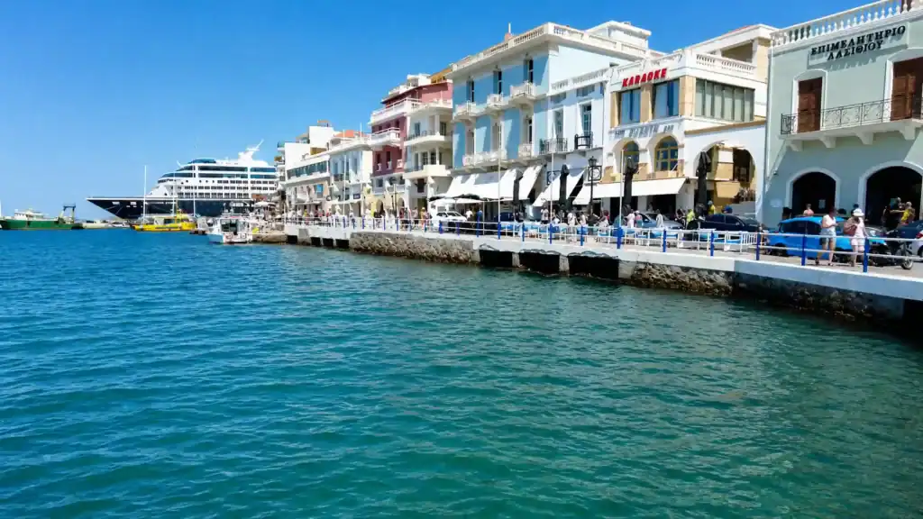 Pastel waterfront buildings and cruise ship along Agios Nikolaos harbour, where to stay in East Crete