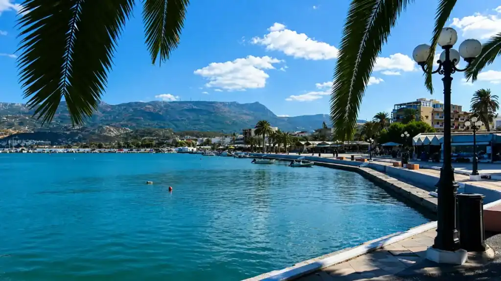 Palm-lined seafront promenade and mountains framing Sitia bay in northeastern Crete