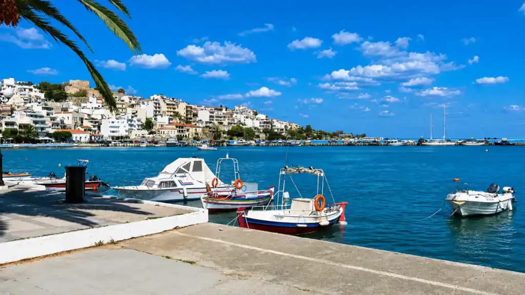 Painted fishing boats moored in Sitia harbour below the Kazarma fortress