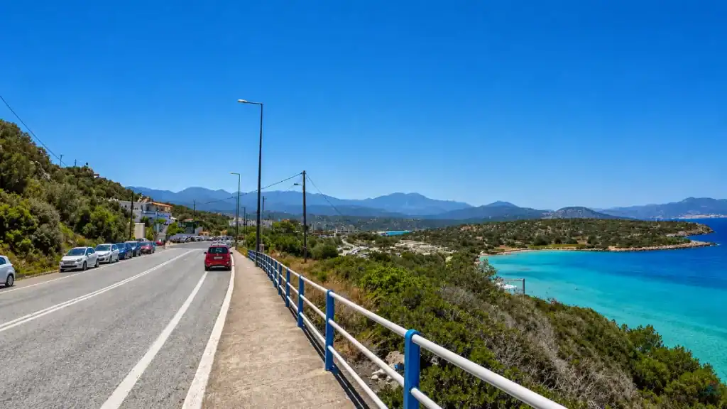 Coastal road curving above the turquoise bay at Voulisma Beach near Istro