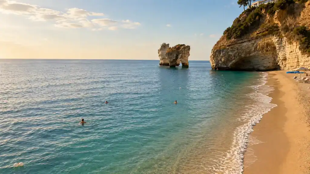 Three swimmers in calm water beside a limestone arch at sunset on the Gargano coast.