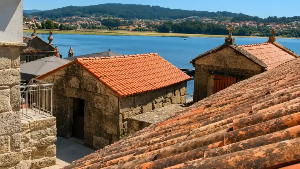 Terracotta rooftops and stone granaries in Combarro village overlooking a wide river estuary