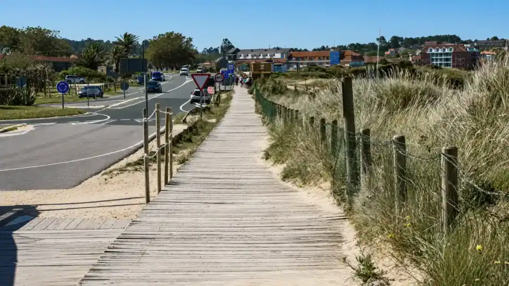 Wooden boardwalk through marram grass dunes leading towards A Lanzada beach, Galicia