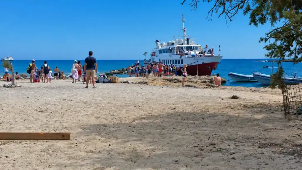 Passengers board a ferry docked at the small jetty on Chrysi islet.