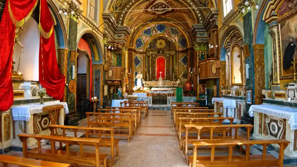 Painted baroque interior and wooden pews inside a church in Vico del Gargano during days in Gargano Puglia.