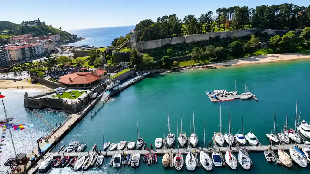 Aerial view of Baiona marina with Monterreal castle walls and turquoise bay beyond