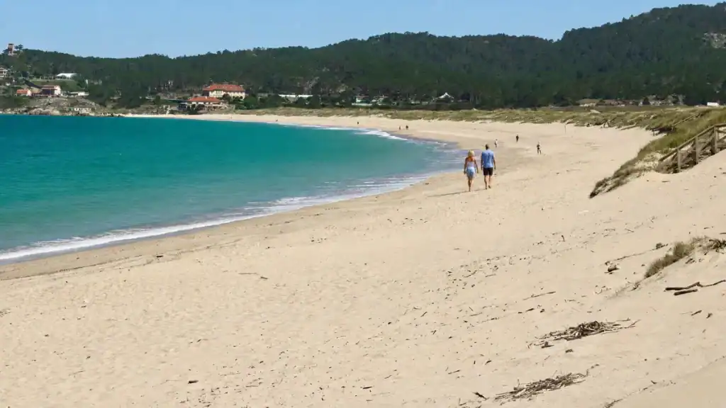 Couple walking the wide sandy sweep of A Lanzada beach with dunes and turquoise water