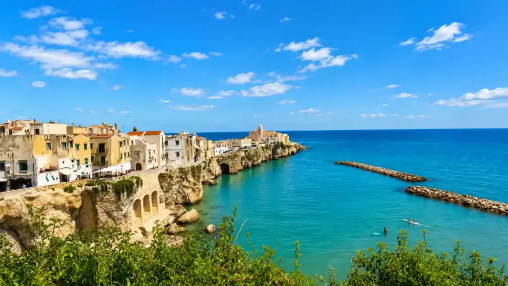 Old town of Vieste perched on limestone cliffs above turquoise water, a centrepiece of East vs North Gargano travel choices.