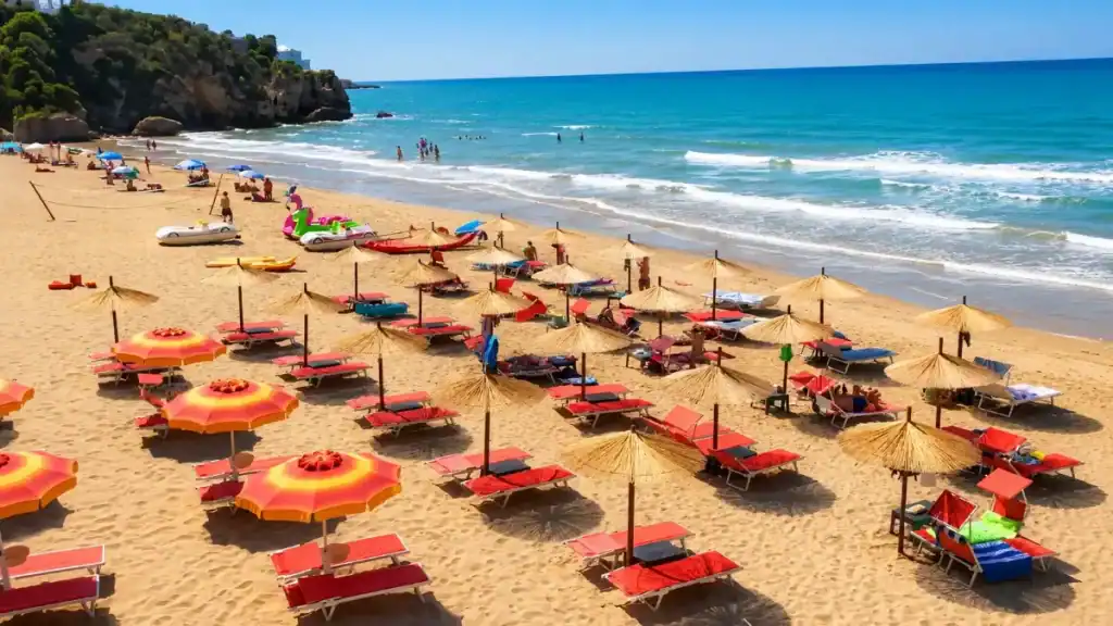 Straw parasols and red sun loungers lining the sand at Spiaggia di Zaiana near Peschici.