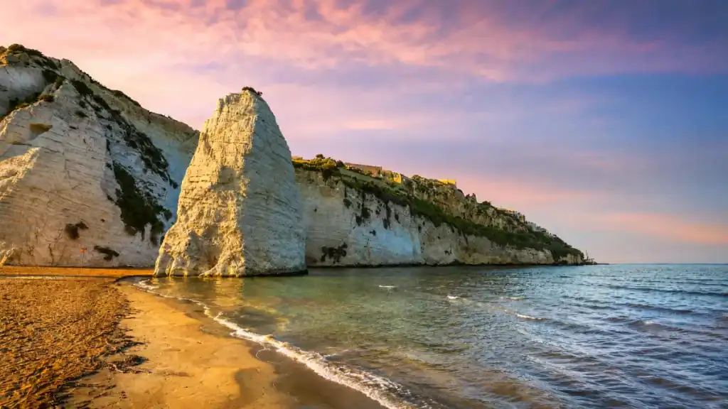 Pizzomunno limestone monolith rising above the sandy shore in Gargano Puglia.