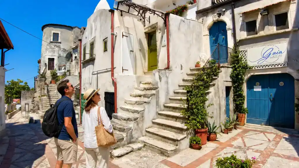 Couple exploring stone staircases in the old quarter of Vico del Gargano, Gargano Puglia.