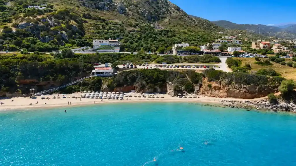 Aerial view of Istro Beach cove with white umbrellas and turquoise water.