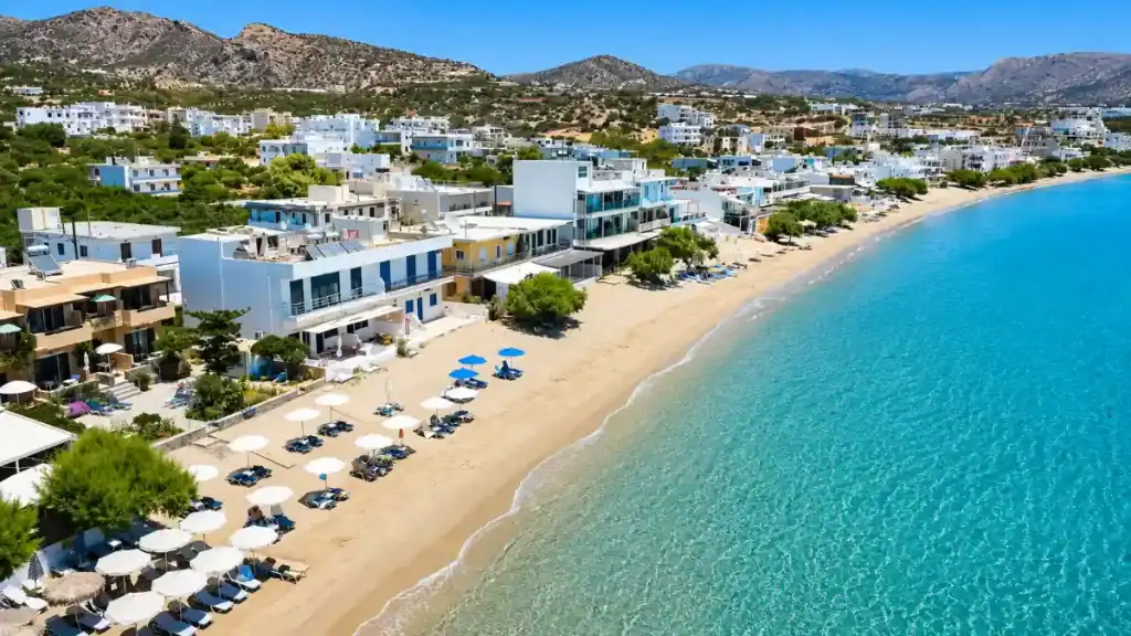 Long sandy strand fronting whitewashed buildings at Makry Gialos on the Libyan Sea.