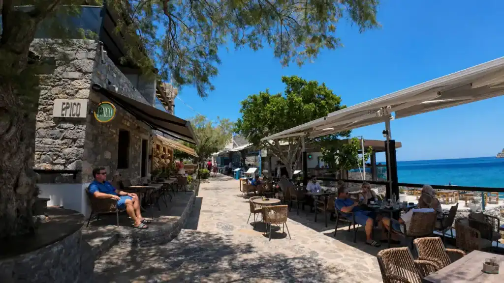 Diners at the stone-built Epico café on the seafront promenade in Plaka.